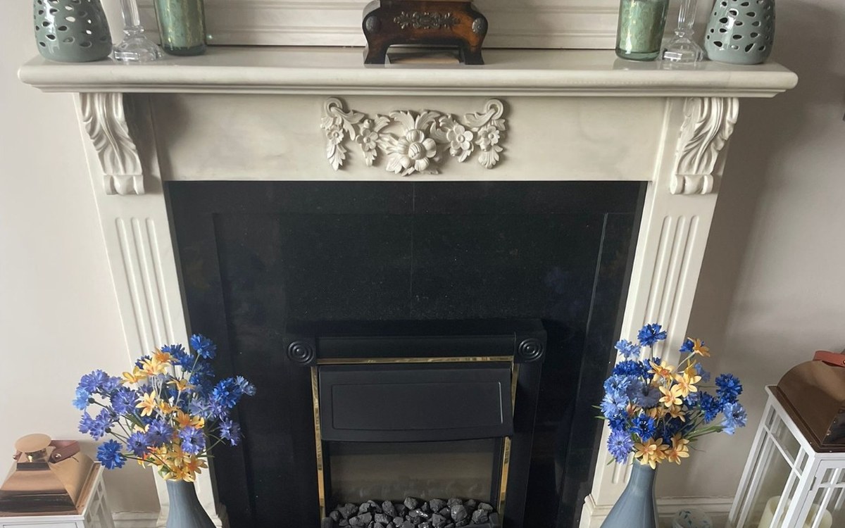 An inset stove fitted by Stove Fit into a period marble fireplace, sitting unlit