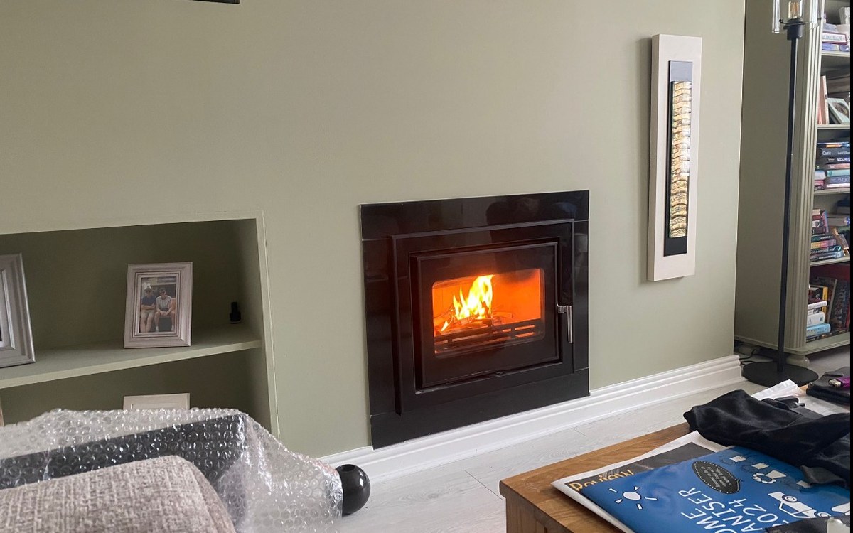 An inset stove fitted flush with the chimney breast by Stove Fit, lit